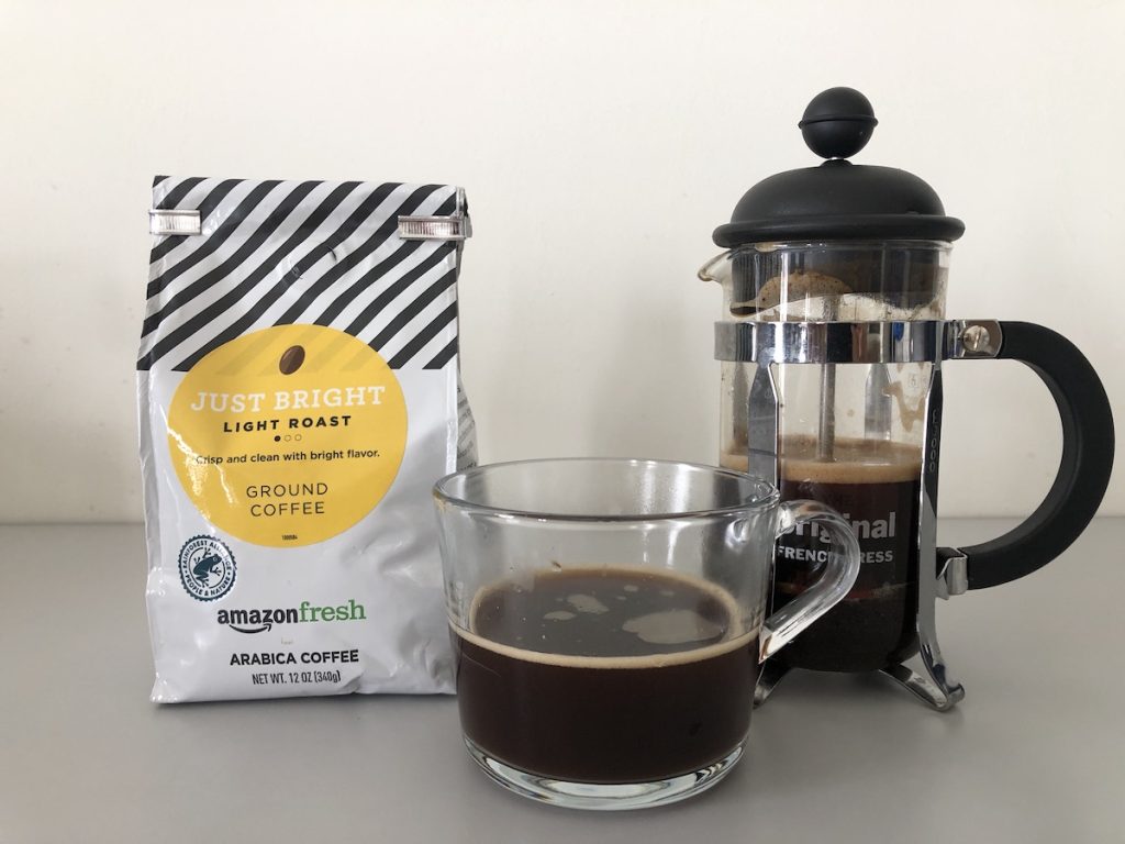 Amazon Fresh Just Bright bag of coffee and french press and cup