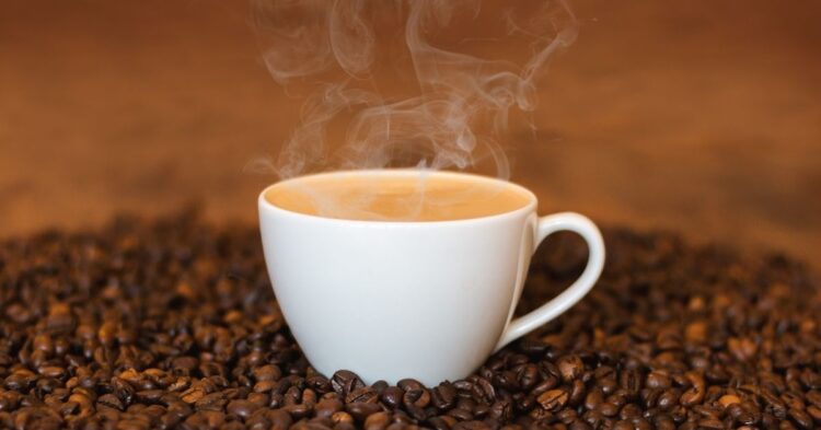 fresh cup of coffee and some beans