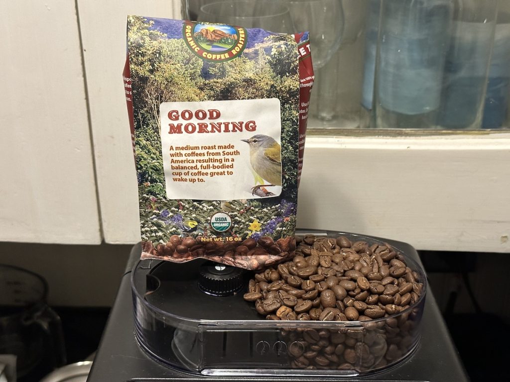 Java Planet organic medium roast coffee package with beans loaded into the espresso machine hopper